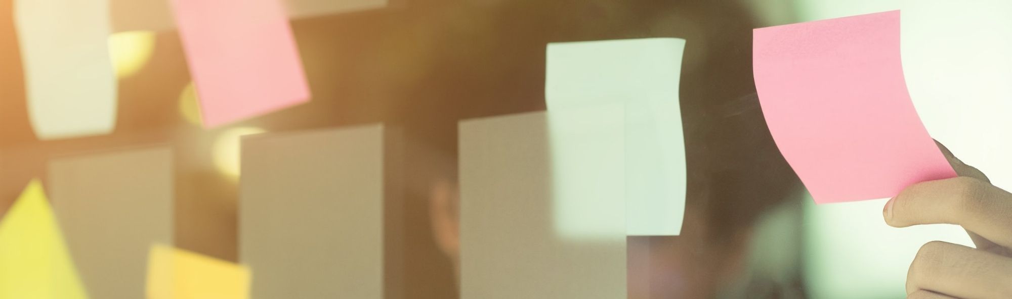 Man pegando post-its nun vidro.