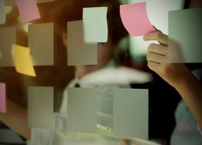 Man poñendo post-its nun vidro.